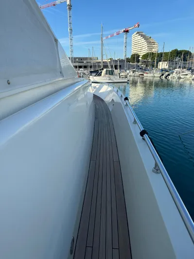 Mazag Yacht Photos Pics Arno Leopard 27 yacht deck, 2007 model, docked in a marina with cranes and buildings.