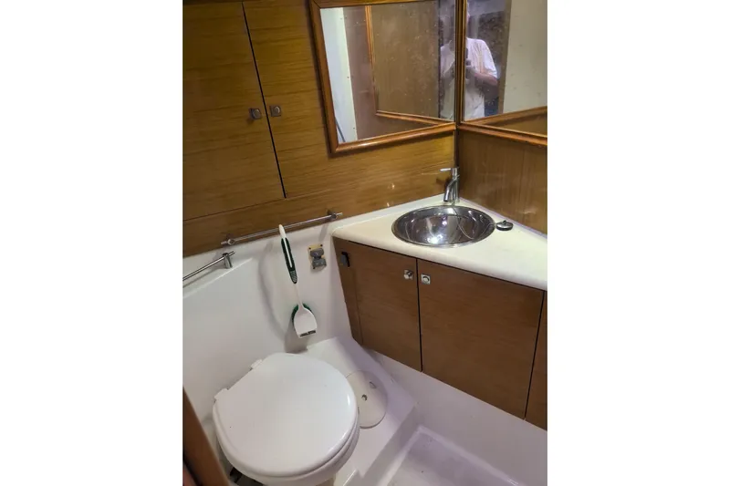 Yacht Photos Pics 2009 Jeanneau Sun Odyssey 44i yacht bathroom with sink, toilet, and wooden cabinetry.