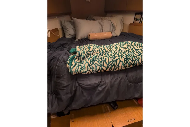  Yacht Photos Pics Cozy cabin bed in 2009 Jeanneau Sun Odyssey 44i sailboat, with patterned blanket and pillows.