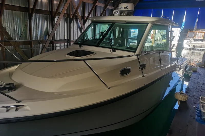  Yacht Photos Pics 2016 Boston Whaler 315 Conquest Pilothouse docked in a covered marina.