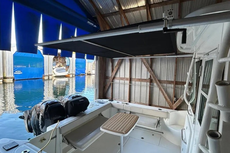  Yacht Photos Pics 2016 Boston Whaler 315 Conquest Pilothouse docked, featuring dual engines and shaded deck area.