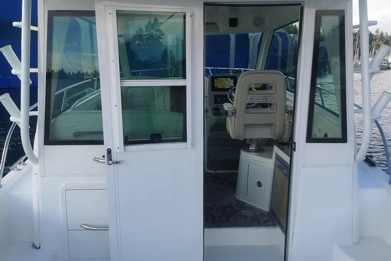  Yacht Photos Pics 2016 Boston Whaler 315 Conquest Pilothouse interior view with helm and seating.