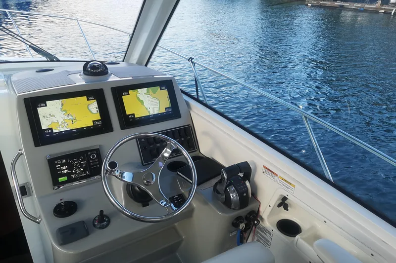  Yacht Photos Pics 2016 Boston Whaler 315 Conquest Pilothouse helm with navigation screens and steering wheel.