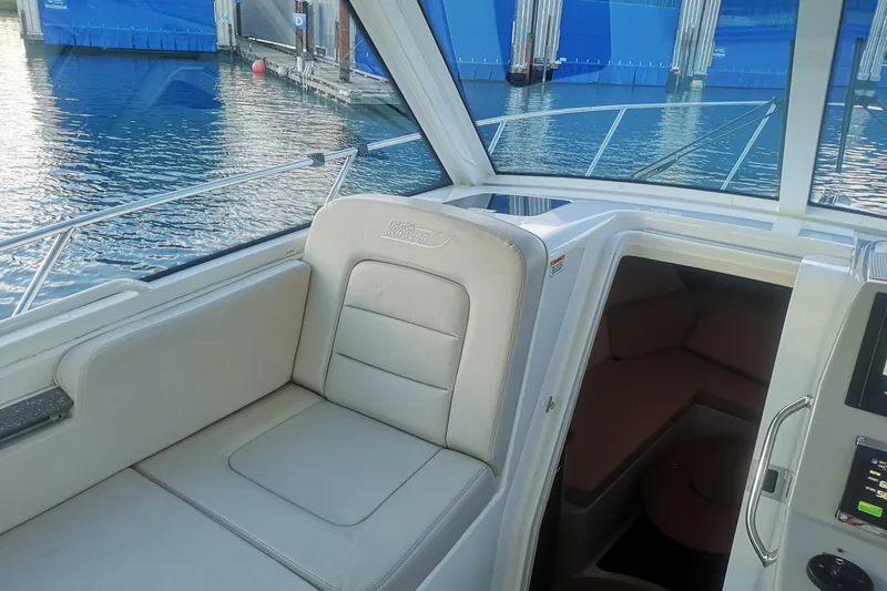  Yacht Photos Pics Interior of 2016 Boston Whaler 315 Conquest Pilothouse, featuring seating and cabin entrance.