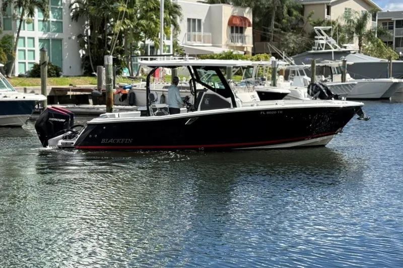  Yacht Photos Pics 2022 Blackfin 272 CC boat cruising in a marina with waterfront homes.