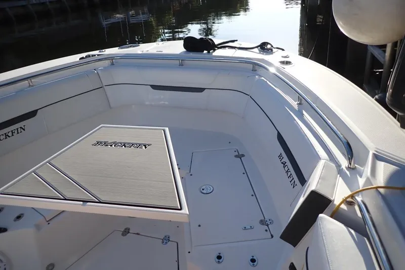  Yacht Photos Pics 2022 Blackfin 272 CC boat interior with seating and table, docked by the water.