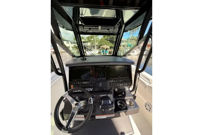  Yacht Photos Pics 2022 Blackfin 272 CC boat cockpit with steering wheel and control panel.