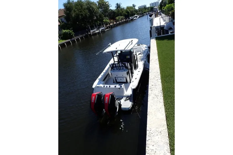  Yacht Photos Pics 2022 Blackfin 272 CC boat docked in a serene canal setting.