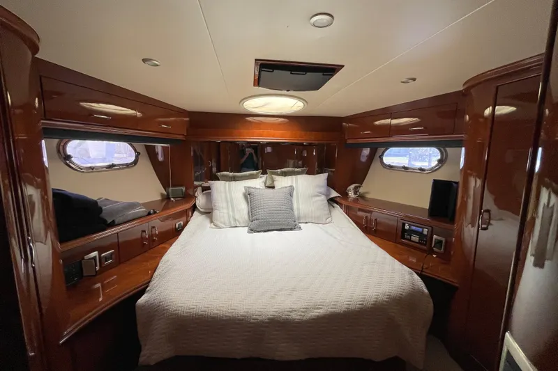  Yacht Photos Pics Luxurious 2006 Marquis 59 yacht bedroom with elegant wood finish and cozy bedding.