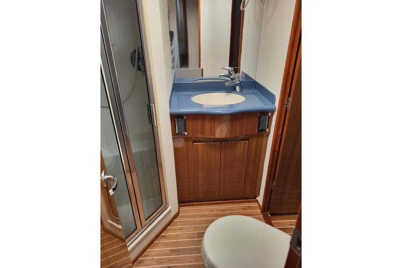  Yacht Photos Pics Bathroom interior of 2008 Viking Boats 60 Convertible with wooden cabinetry and blue countertop.