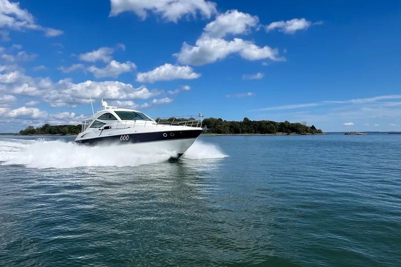 Dolcinea Yacht Photos Pics 2010 Cruisers Yachts 520 Sports Coupe cruising on open water under blue sky.