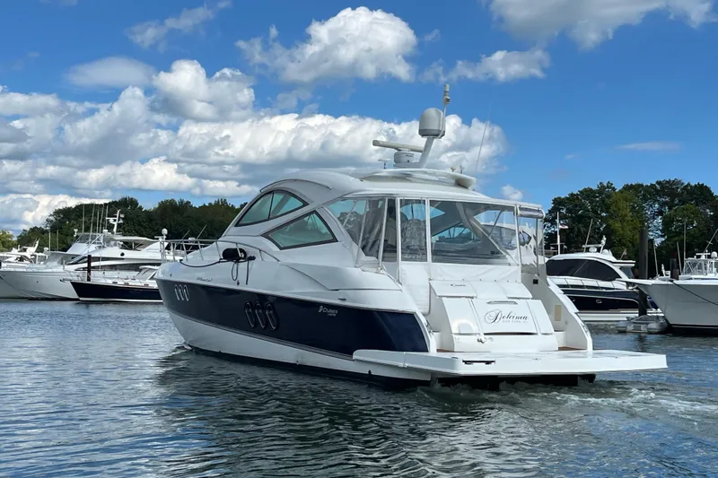 Dolcinea Yacht Photos Pics 2010 Cruisers Yachts 520 Sports Coupe on water, clear sky, marina background.