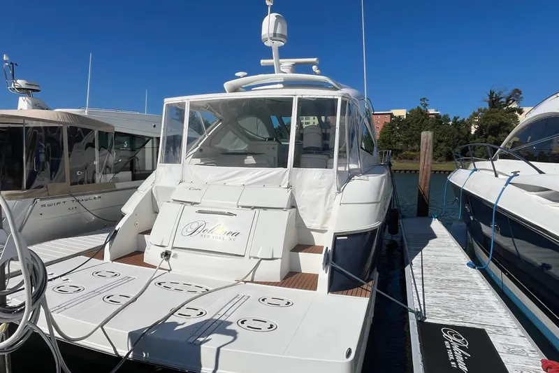 Dolcinea Yacht Photos Pics 2010 Cruisers Yachts 520 Sports Coupe docked at marina under clear blue sky.