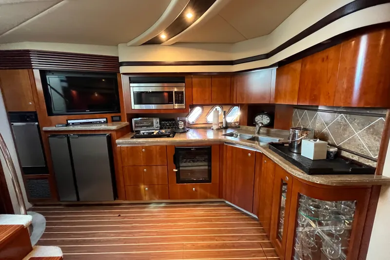 Dolcinea Yacht Photos Pics Luxurious 2010 Cruisers Yachts 520 Sports Coupe kitchen with modern appliances and elegant wood finish.