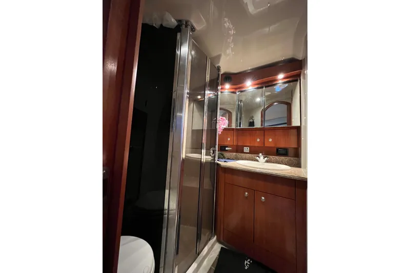 Dolcinea Yacht Photos Pics Luxurious bathroom in 2010 Cruisers Yachts 520 Sports Coupe with wood cabinetry and glass shower.