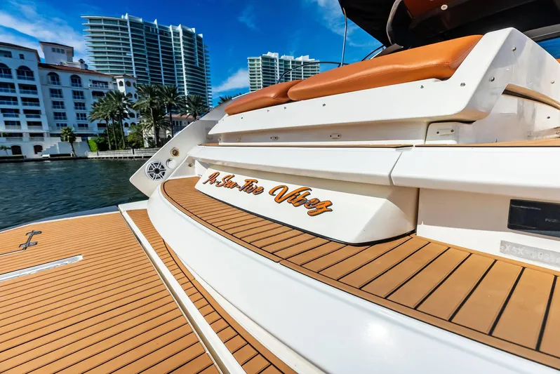 Po-sea-tive Vibez Yacht Photos Pics 2013 Azimut Atlantis 48 yacht with teak deck, docked near modern buildings.