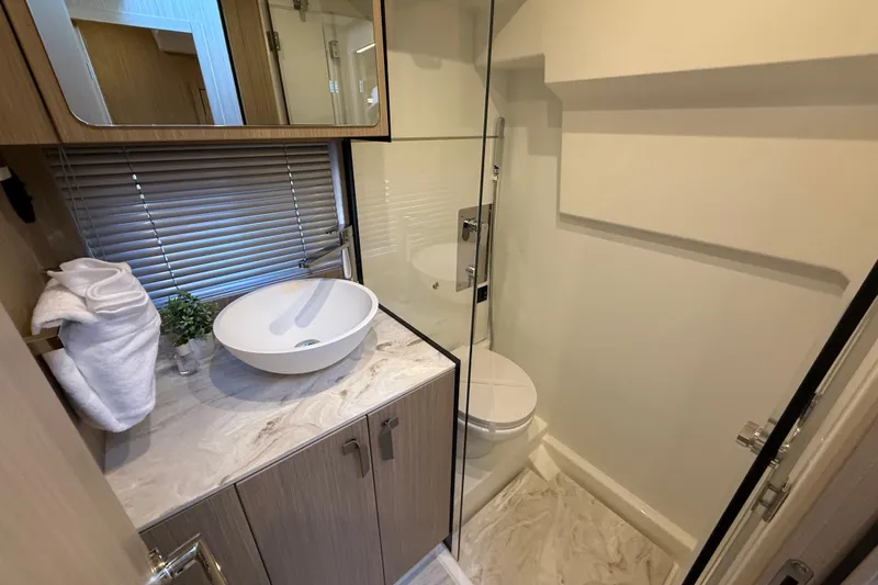  Yacht Photos Pics Modern bathroom in 2026 Prestige F4.3, featuring sleek sink and glass shower.