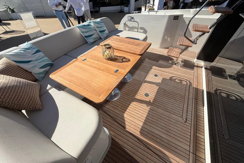  Yacht Photos Pics Luxurious seating area on 2026 Prestige F4.3 yacht with wooden table and cushions.