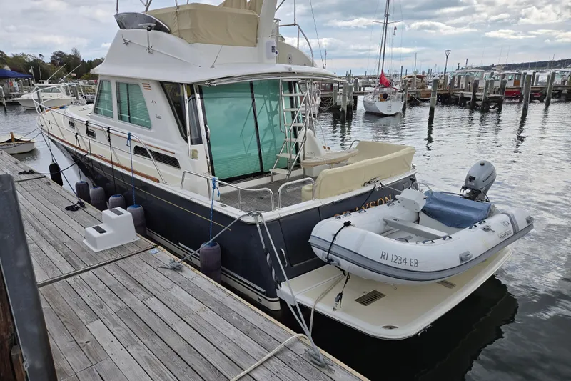 Grayson Yacht Photos Pics 2017 Sabre 48 Fly Bridge yacht docked with inflatable boat attached.