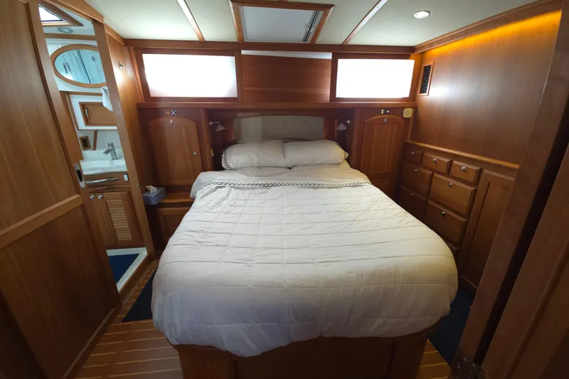 Grayson Yacht Photos Pics Luxurious 2017 Sabre 48 Fly Bridge yacht bedroom with wood paneling and cozy bedding.