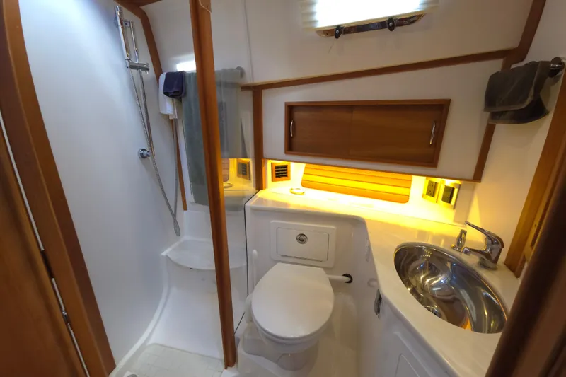 Grayson Yacht Photos Pics 2017 Sabre 48 Fly Bridge yacht bathroom with shower, sink, and wooden cabinetry.