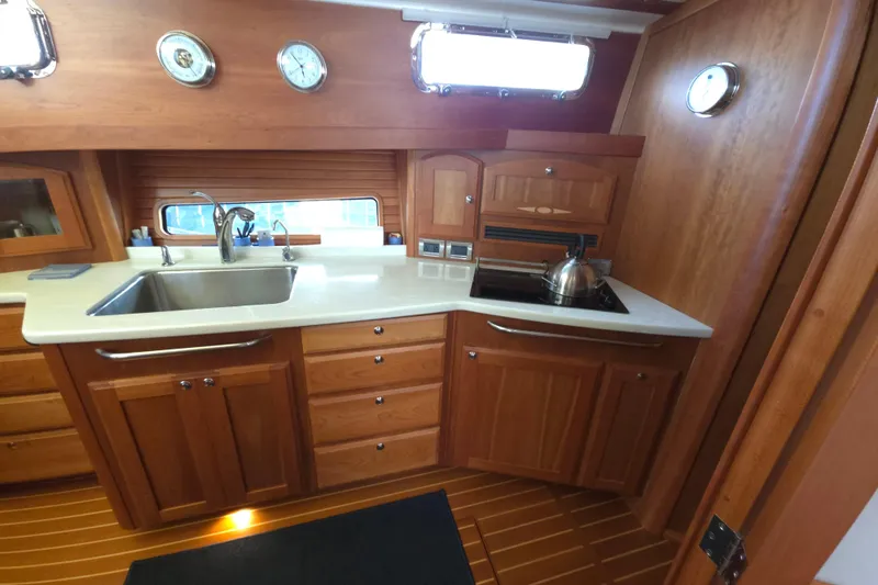 Grayson Yacht Photos Pics Luxurious 2017 Sabre 48 Fly Bridge yacht kitchen with wooden cabinetry and modern appliances.