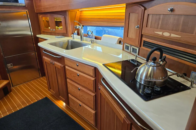 Grayson Yacht Photos Pics Luxurious 2017 Sabre 48 Fly Bridge yacht kitchen with wood cabinetry and modern appliances.