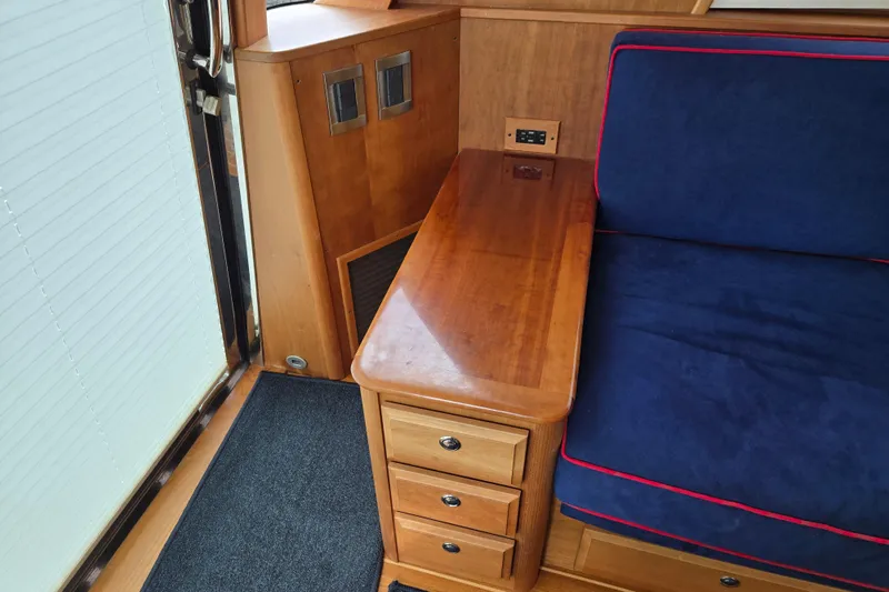 Grayson Yacht Photos Pics 2017 Sabre 48 Fly Bridge interior with wooden cabinetry and blue cushioned seating.
