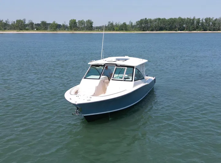  Yacht Photos Pics 2019 Grady-White Freedom 375 boat on calm water, with distant shoreline.
