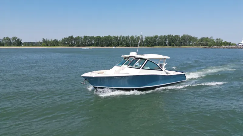  Yacht Photos Pics 2019 Grady-White Freedom 375 cruising on a calm lake under clear blue skies.