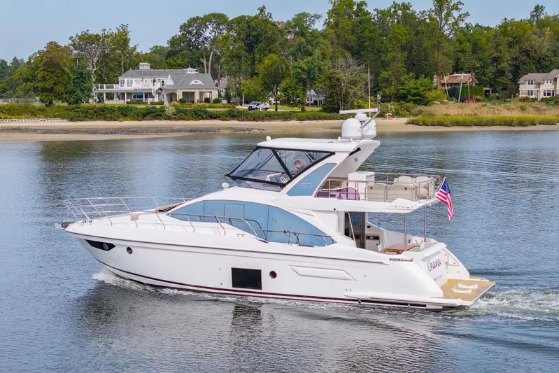  Yacht Photos Pics 2020 Azimut Fly 50 yacht cruising on a serene lake with lush greenery in the background.