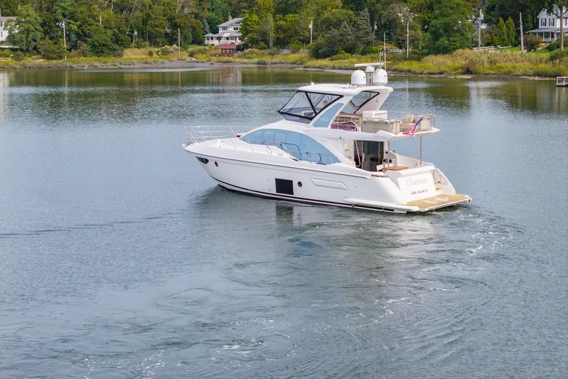  Yacht Photos Pics Azimut Fly 50 yacht cruising on a serene lake, surrounded by lush greenery.