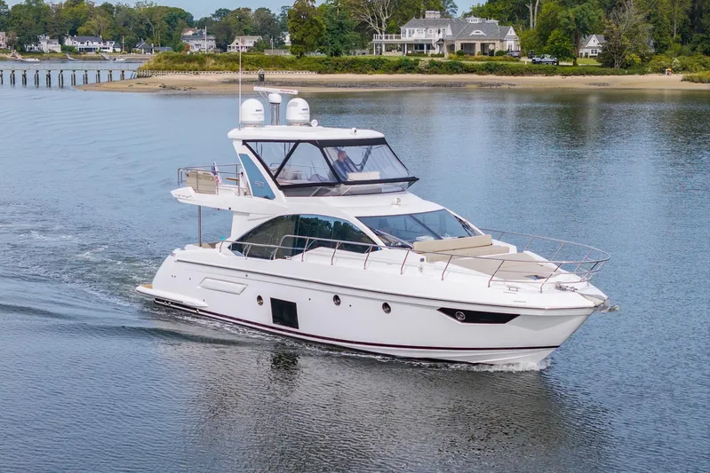  Yacht Photos Pics 2020 Azimut Fly 50 yacht cruising on a serene waterway near luxury homes.
