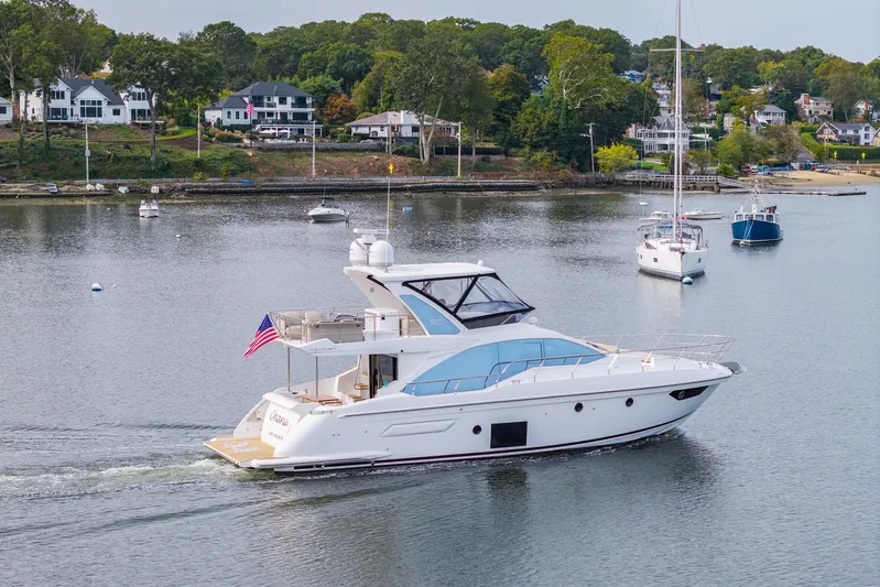  Yacht Photos Pics Azimut Fly 50 yacht cruising on a serene lake, surrounded by sailboats and lush greenery.