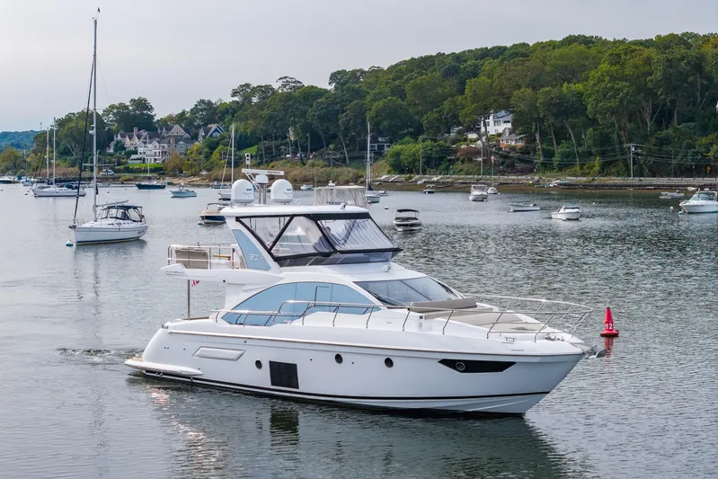  Yacht Photos Pics 2020 Azimut Fly 50 yacht cruising in a scenic harbor with lush greenery.