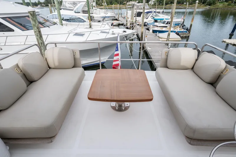  Yacht Photos Pics Azimut Fly 50 yacht deck with beige seating and wooden table, docked at marina.