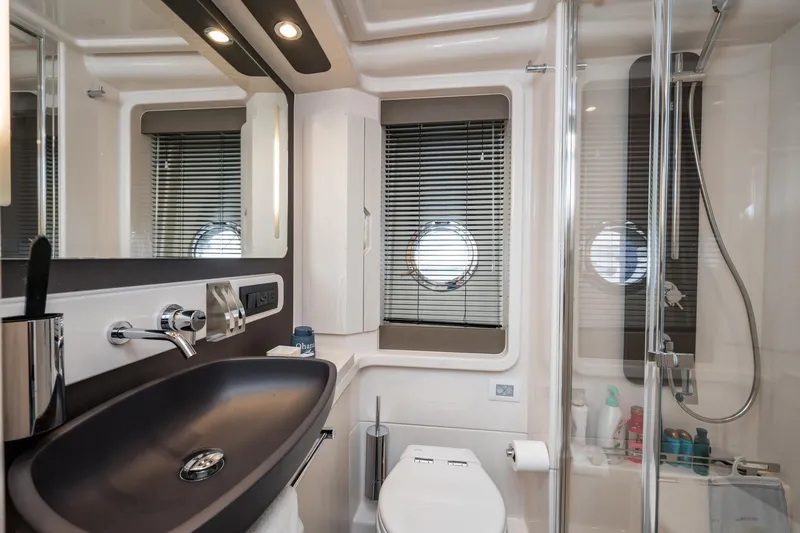  Yacht Photos Pics Luxurious bathroom in 2020 Azimut Fly 50 yacht with modern fixtures and porthole window.