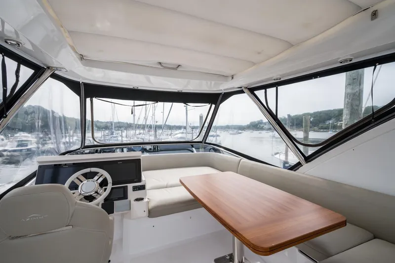  Yacht Photos Pics 2020 Azimut Fly 50 yacht interior with helm, seating, and table, overlooking marina.