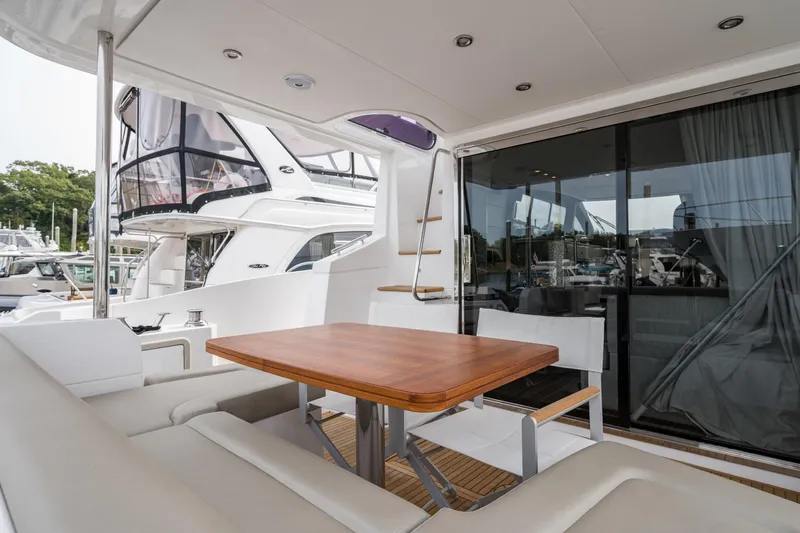  Yacht Photos Pics Luxurious 2020 Azimut Fly 50 yacht with elegant outdoor seating and wooden table.