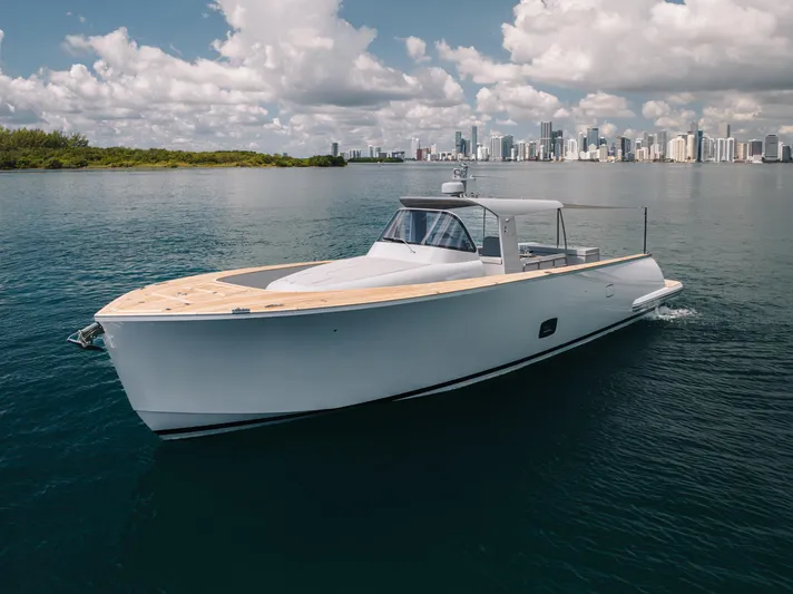 M/y Valor Yacht Photos Pics 2021 Alen 55 yacht cruising on calm waters with city skyline in background.