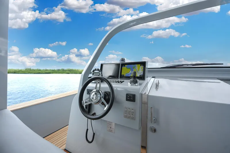 M/y Valor Yacht Photos Pics Helm of 2021 Alen 55 yacht with navigation system, steering wheel, and serene water view.