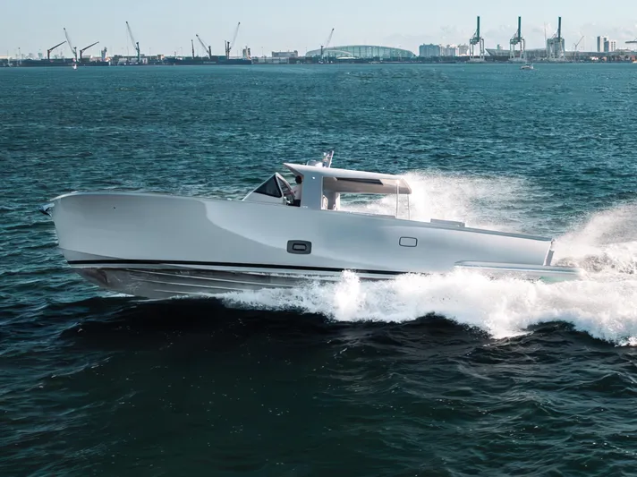 M/y Valor Yacht Photos Pics 2021 Alen 55 yacht cruising on open water with city skyline in background.