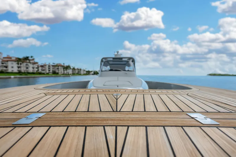 M/y Valor Yacht Photos Pics 2021 Alen 55 yacht on water, wooden deck, cloudy sky background.