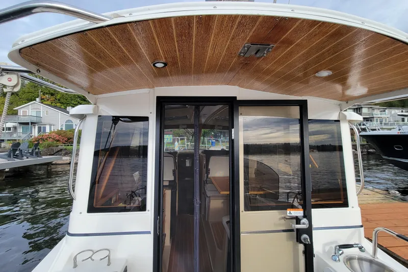  Yacht Photos Pics 2017 Cutwater C28 boat with wooden ceiling, docked by waterfront homes.