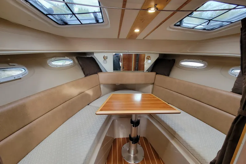  Yacht Photos Pics Interior of 2017 Cutwater C28 boat with cozy seating and wooden table.