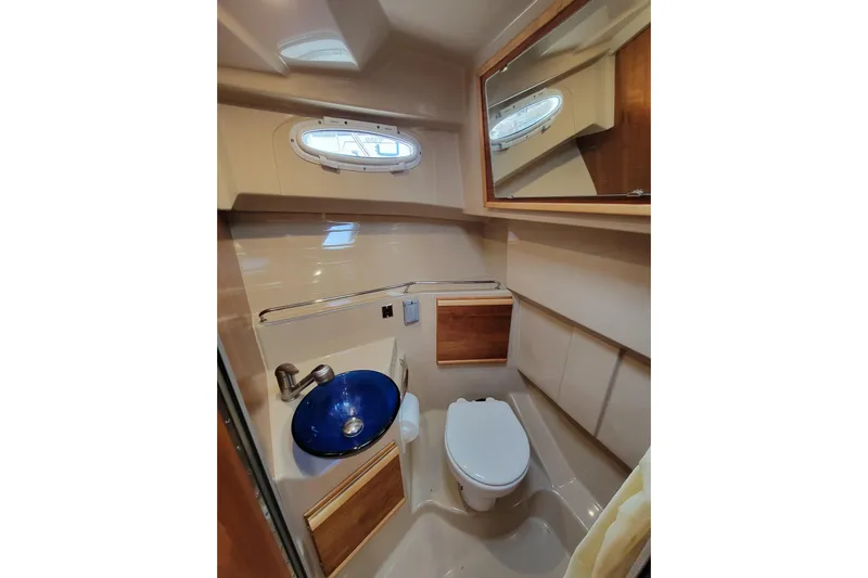  Yacht Photos Pics 2017 Cutwater C28 boat bathroom with blue sink, toilet, and mirror.