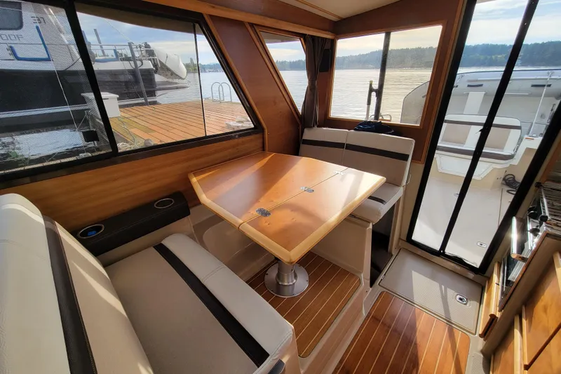  Yacht Photos Pics Interior of 2017 Cutwater C28 boat with wooden table and seating area.