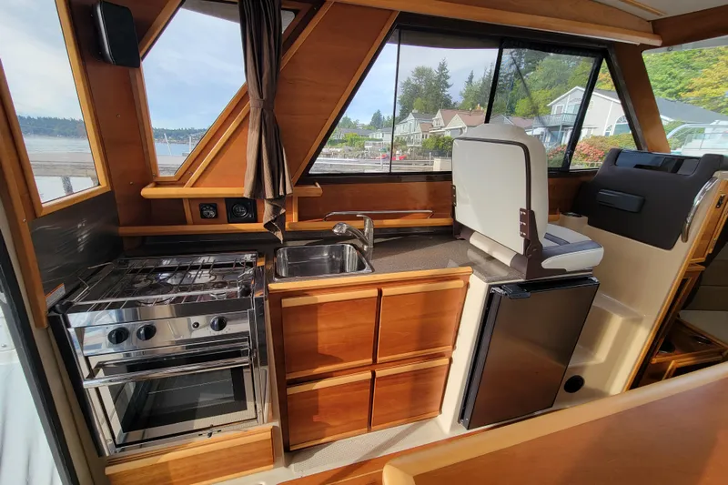  Yacht Photos Pics 2017 Cutwater C28 interior with kitchen, stove, sink, and seating, showcasing elegant wood finish.