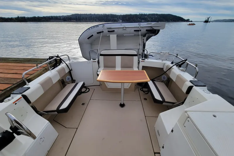  Yacht Photos Pics 2017 Cutwater C28 boat interior with seating and table, docked by a calm lake.