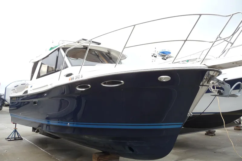  Yacht Photos Pics 2017 Cutwater C28 boat with sleek navy hull, docked on land.